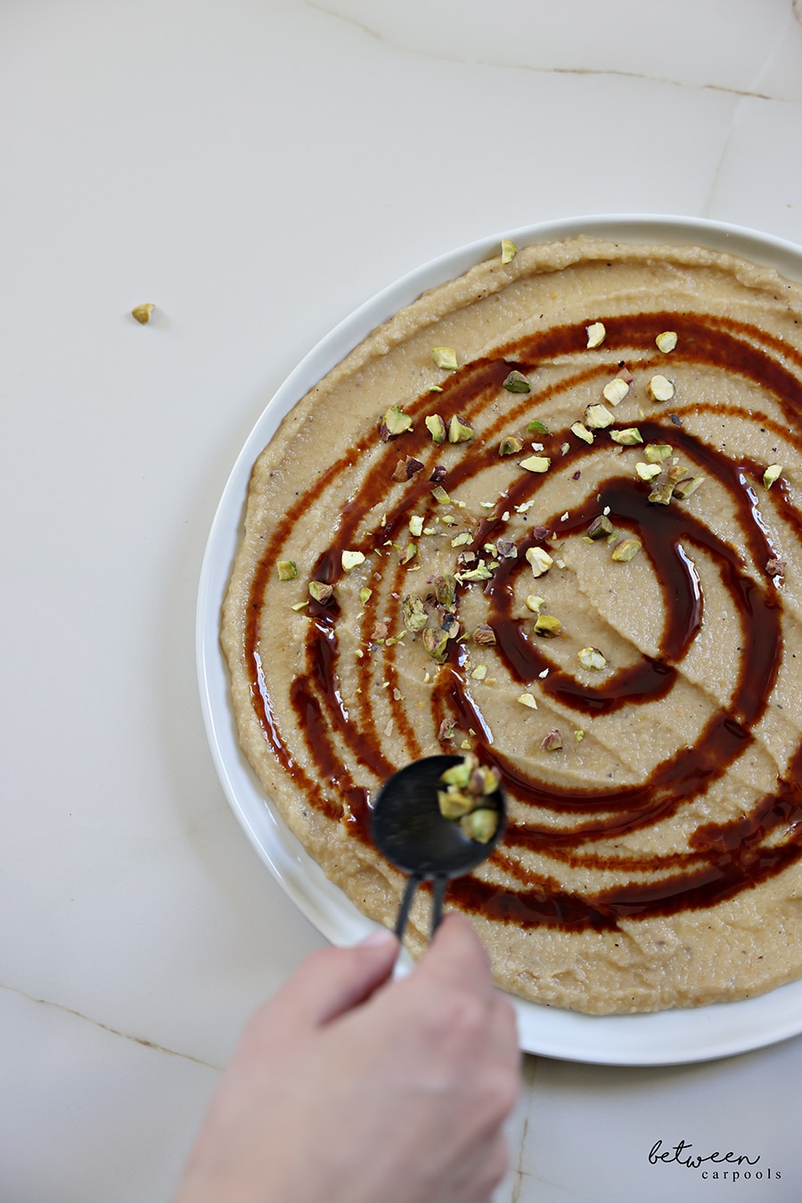 topping creamy eggplant and silan with feta and pistachios