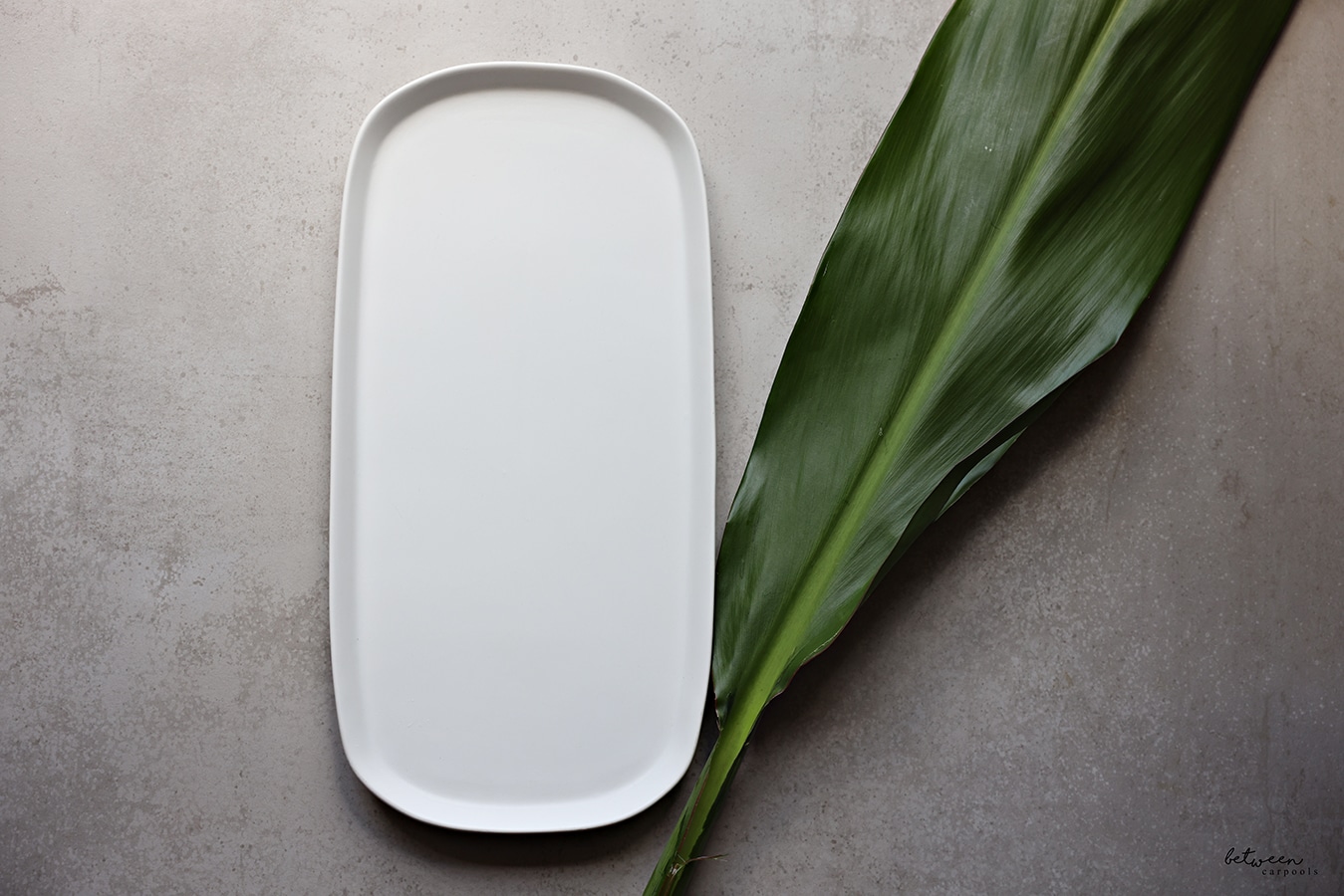white oval tray and a banana leaf near it