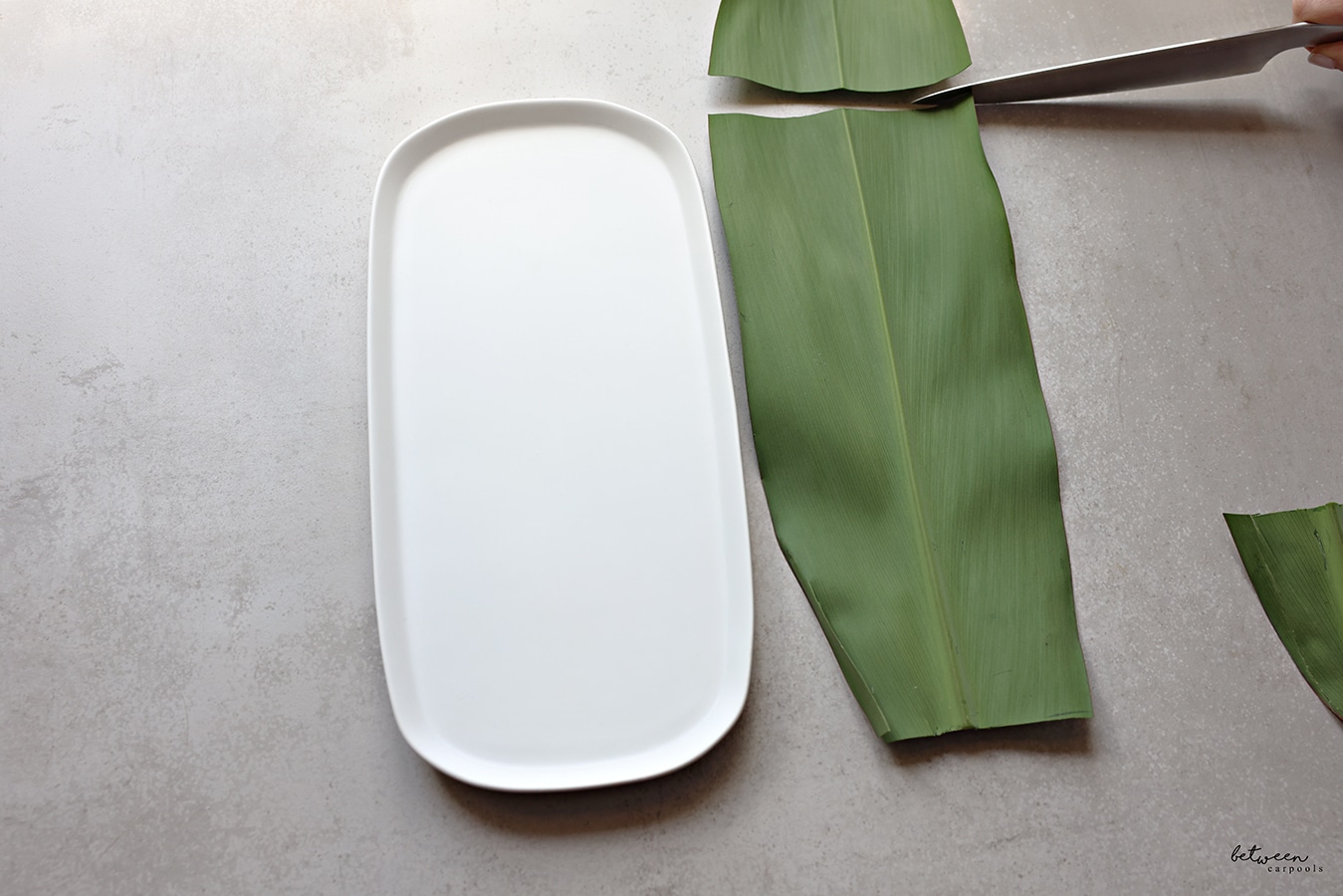 Cutting the Banana Leaf to the size of the platter.