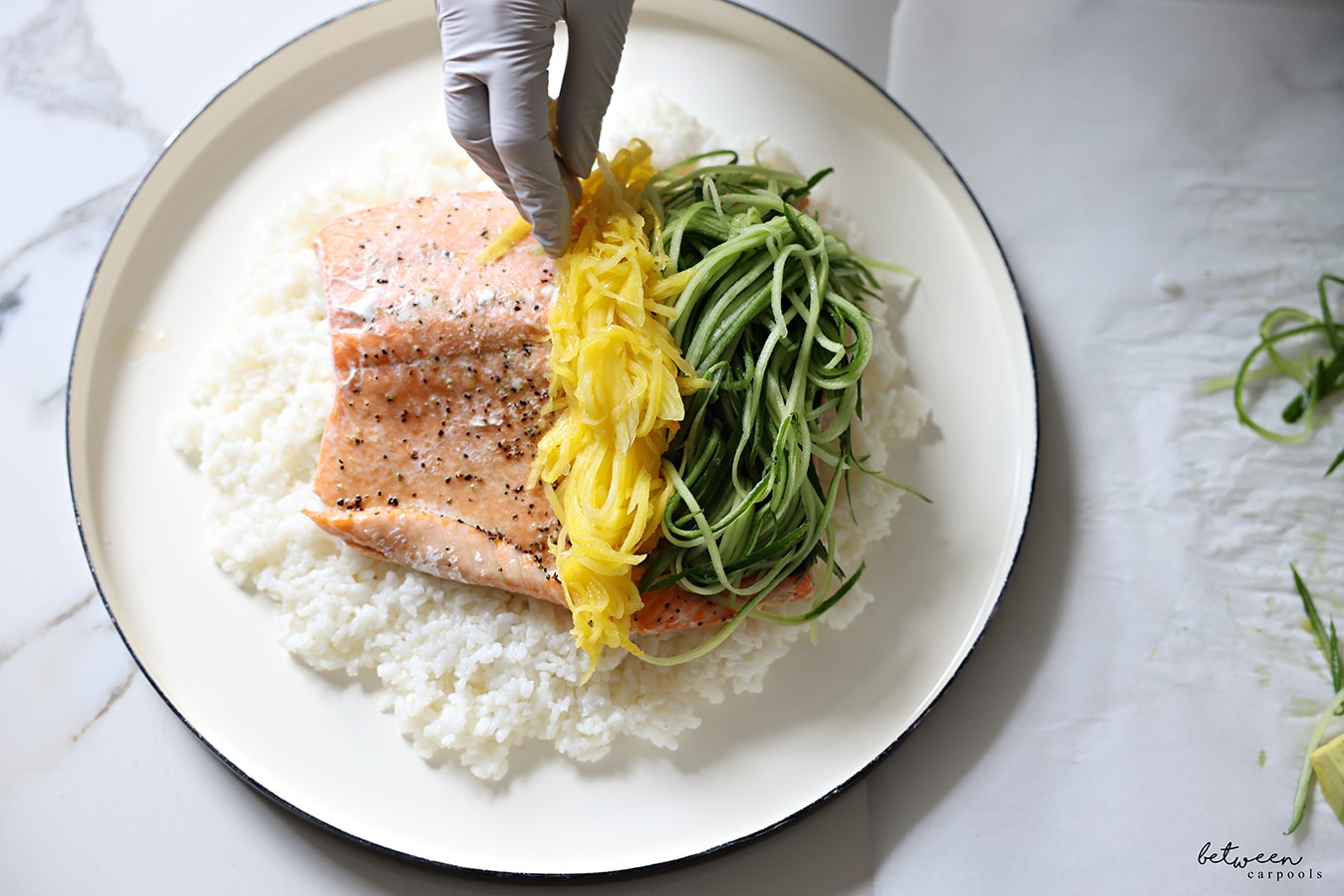 topping the salmon with cucumber and mango