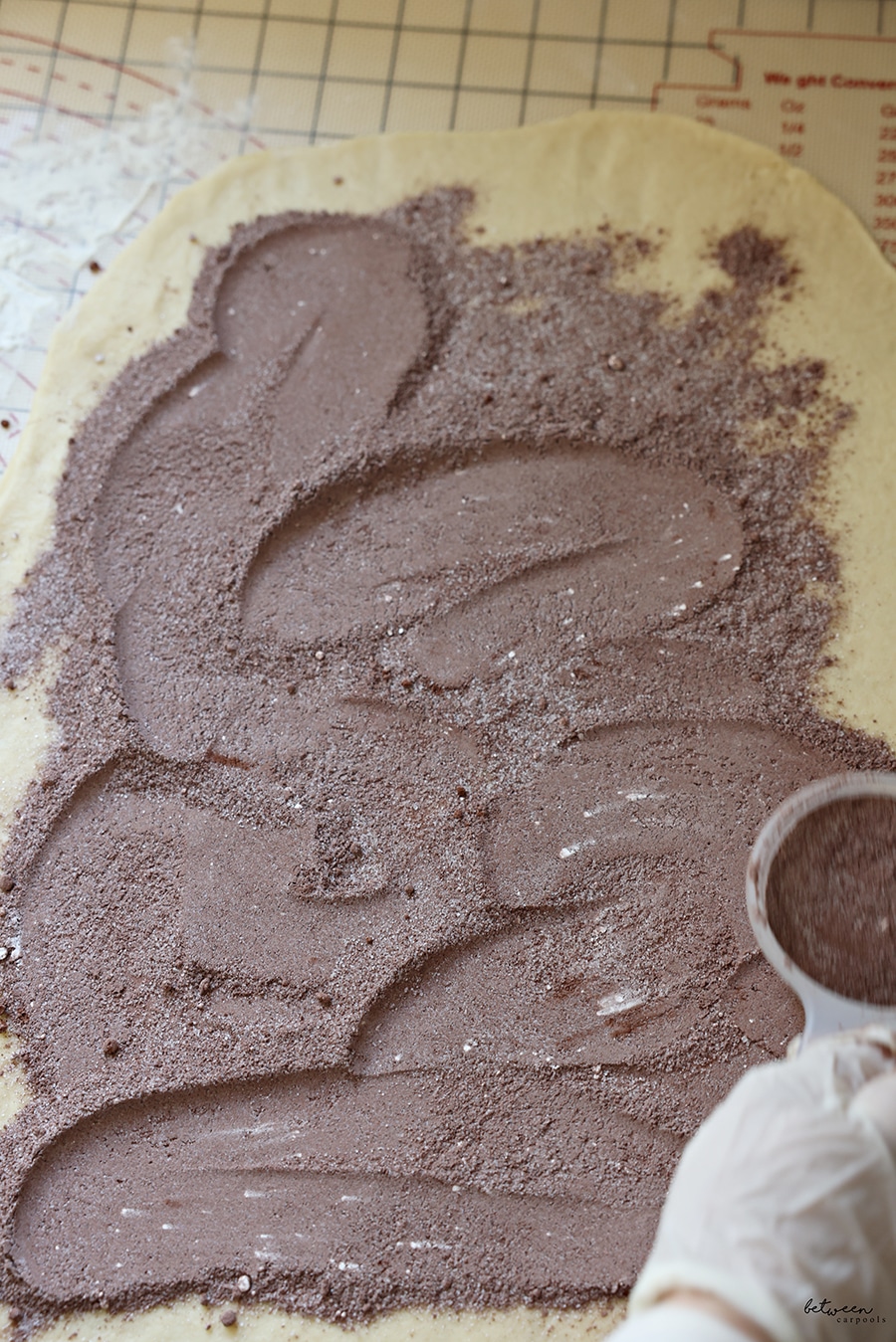 cocoa + sugars on rolled out kokosh cake dough on a baking mat