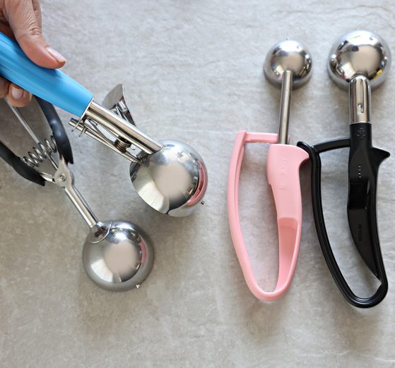 Saebye Portion Scoop in hand. 2 Zeroll EZ Disher (Pink and Black) on the side