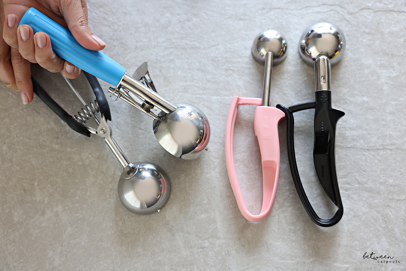 Saebye Portion Scoop in hand. 2 Zeroll EZ Disher (Pink and Black) on the side