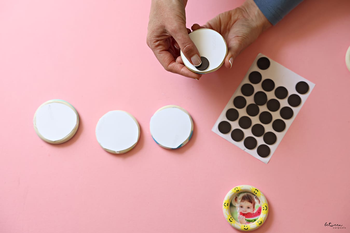 sticking a self-adhesive magnet dot onto the picture glued to a wooden ring