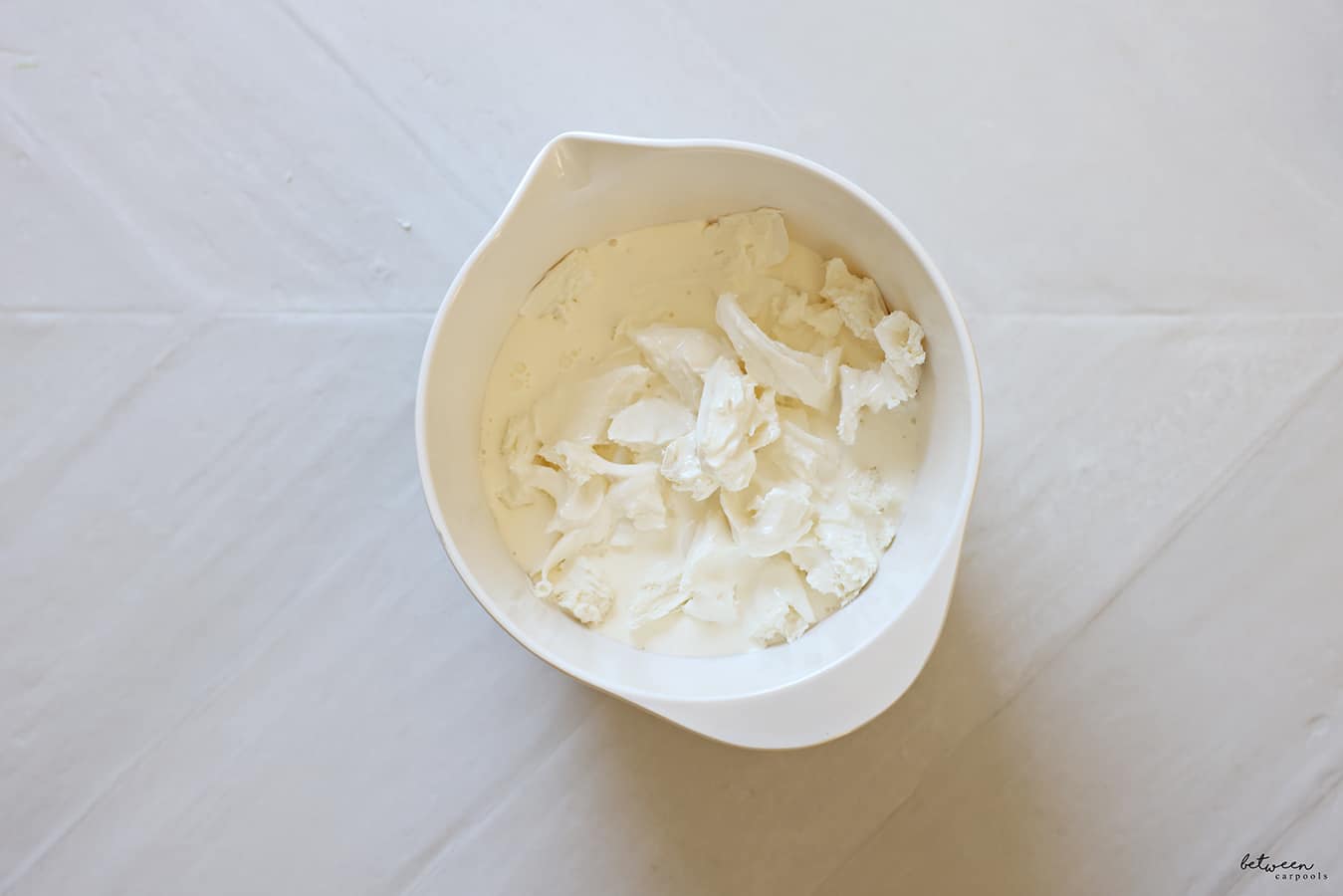 heavy cream, salt, and shredded fresh mozzarella cheese in a spouted mixing bowl
