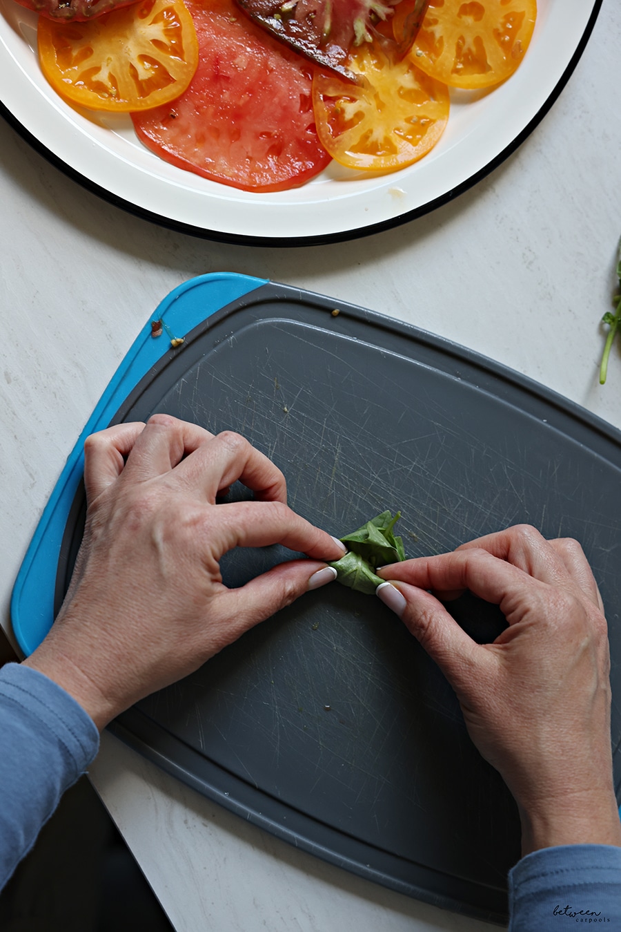 chiffonade basil leaves on a cutting board
