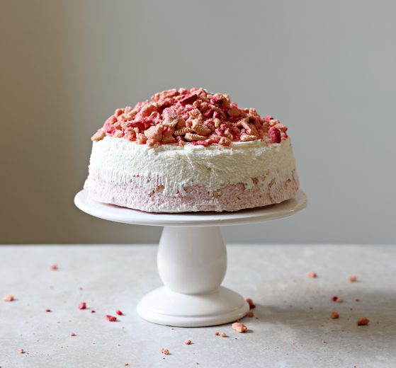 Strawberry Crunch Ice Cream Cake on a cake plate, topped