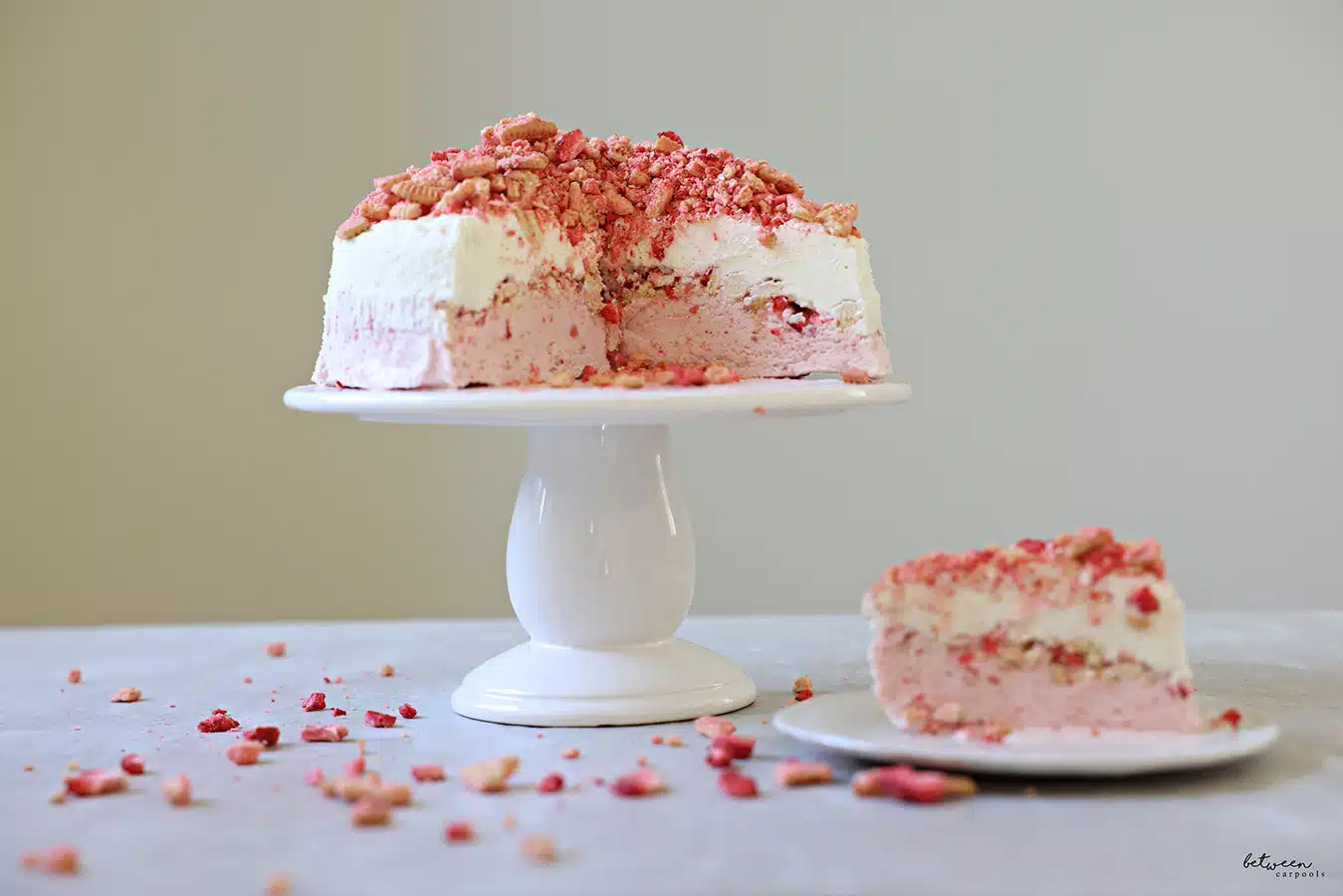 Strawberry Crunch Ice Cream on a cake plate, topped with the rest of the crumbs.