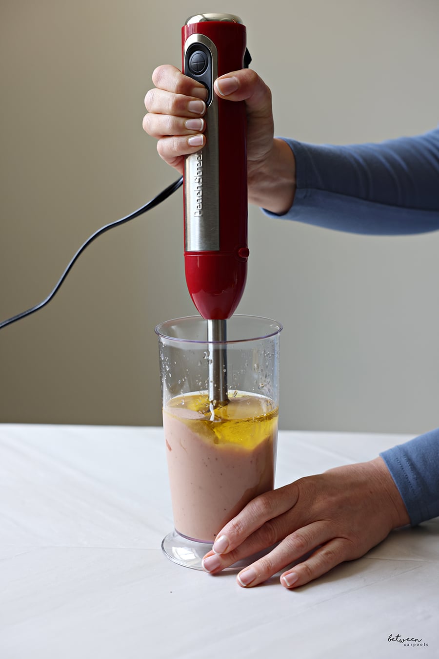 Blending all dressing ingredients using an immersion blender.