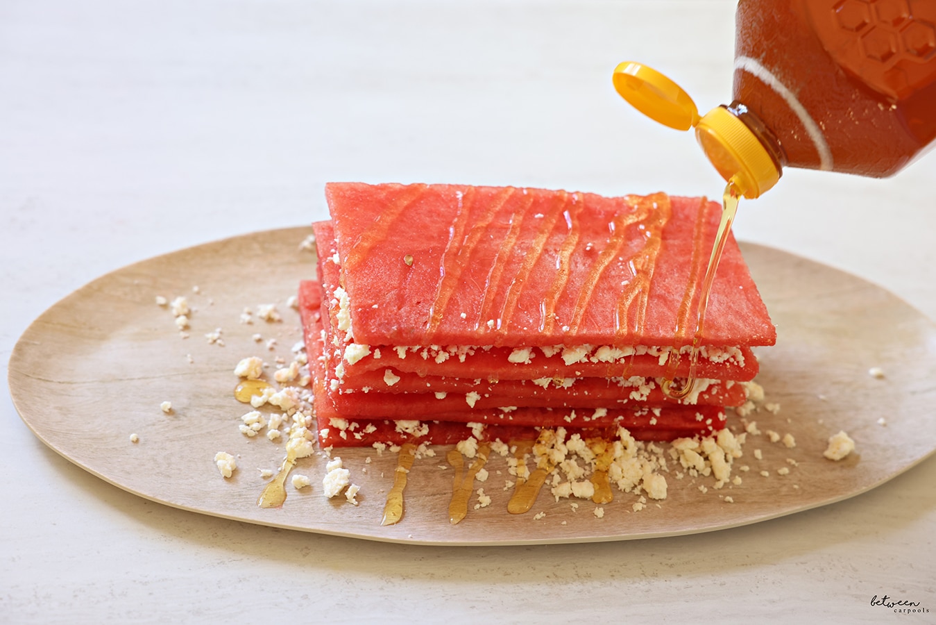 Topping watermelon and feta with honey