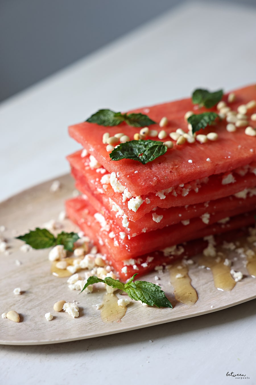 Watermelon and feta topped with honey, some nuts, and chopped mint leaves