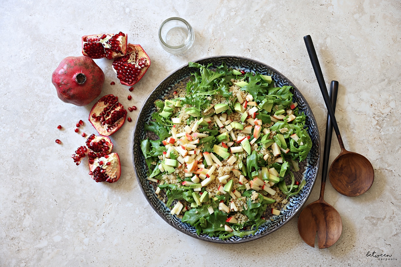 Quinoa, avocado, and tiny cubed apple added to the plated dark greens.