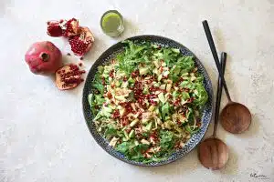 Plated salad, and a small jar of dressing nearby.