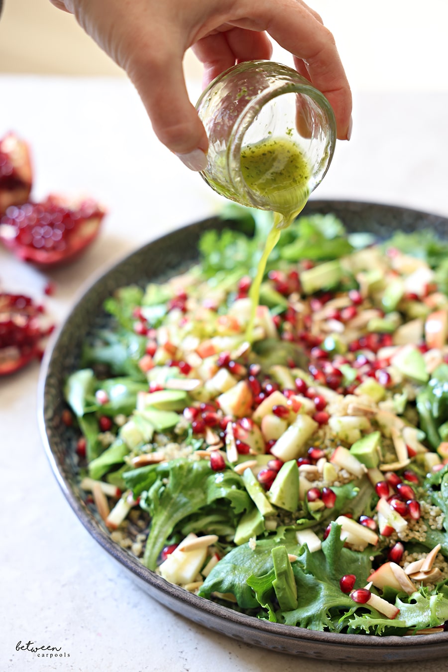 Pouring dressing over plated salad.