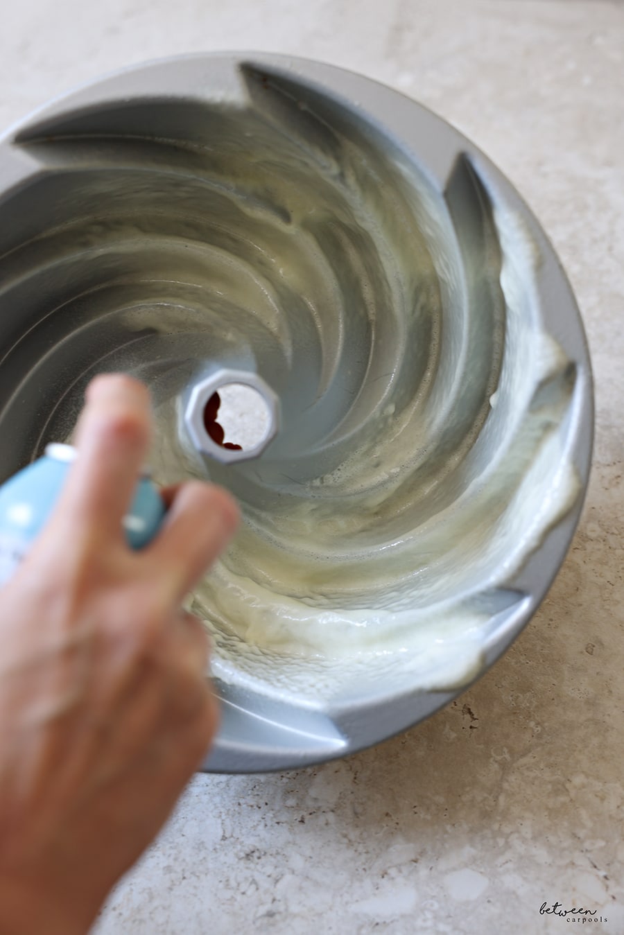 Greasing a bundt pan with PAM Baking spray.
