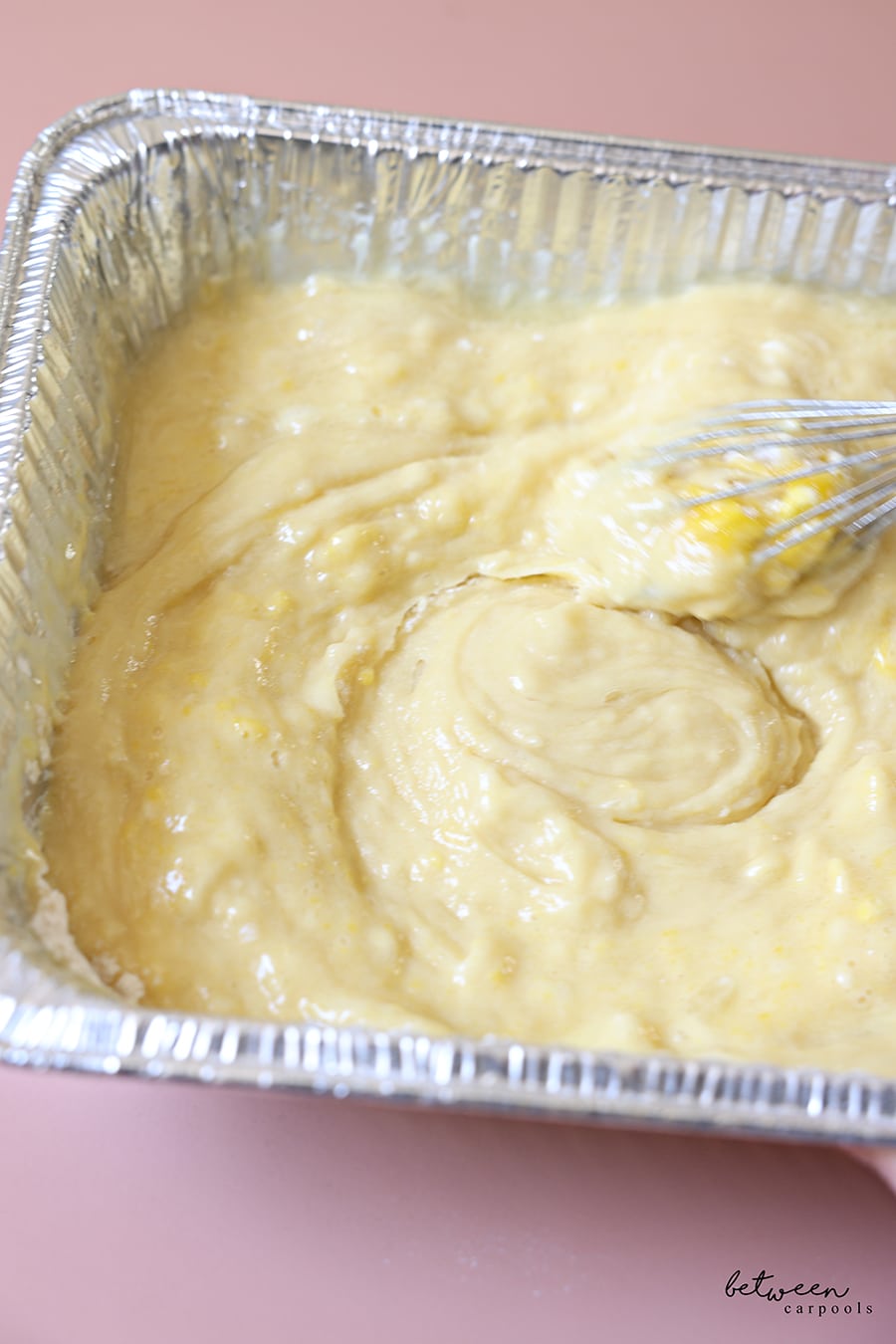 Mixing the cake batter in a 9x13 disposable foil pan.