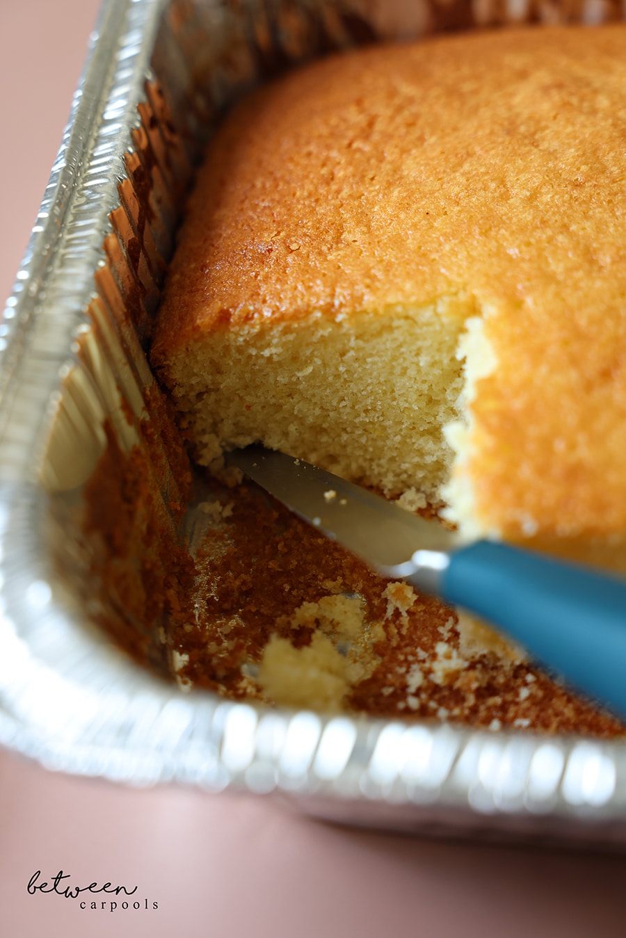 Few slices cut from baked cake in a 9x13 disposable foil pan.