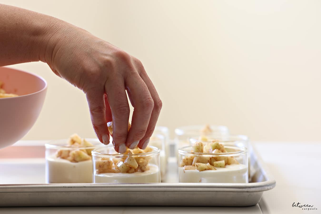 Topping the cheesecake mixture with apples