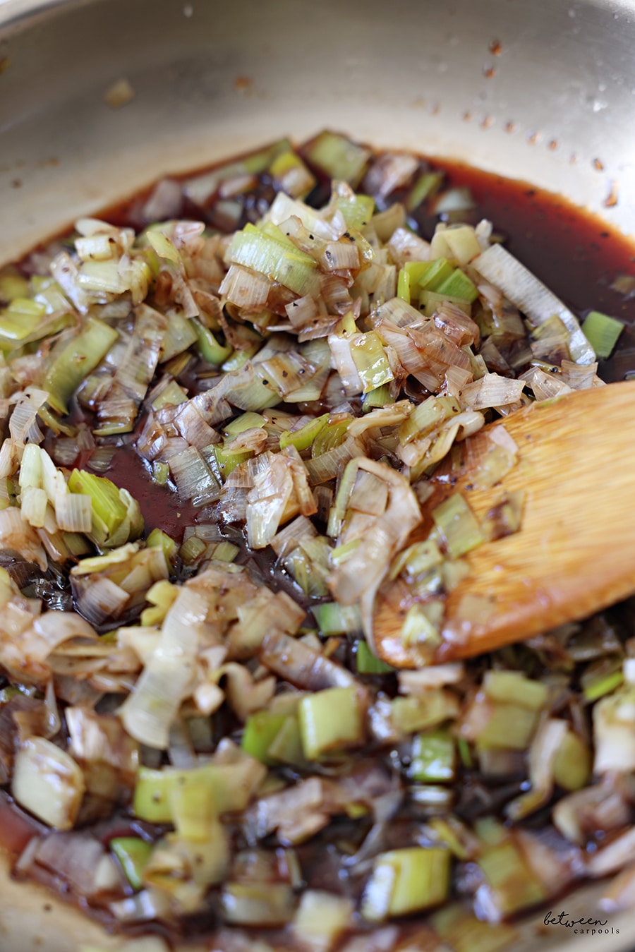 Pomegranate concentrate in a pan with sautéed and seasoned leeks.