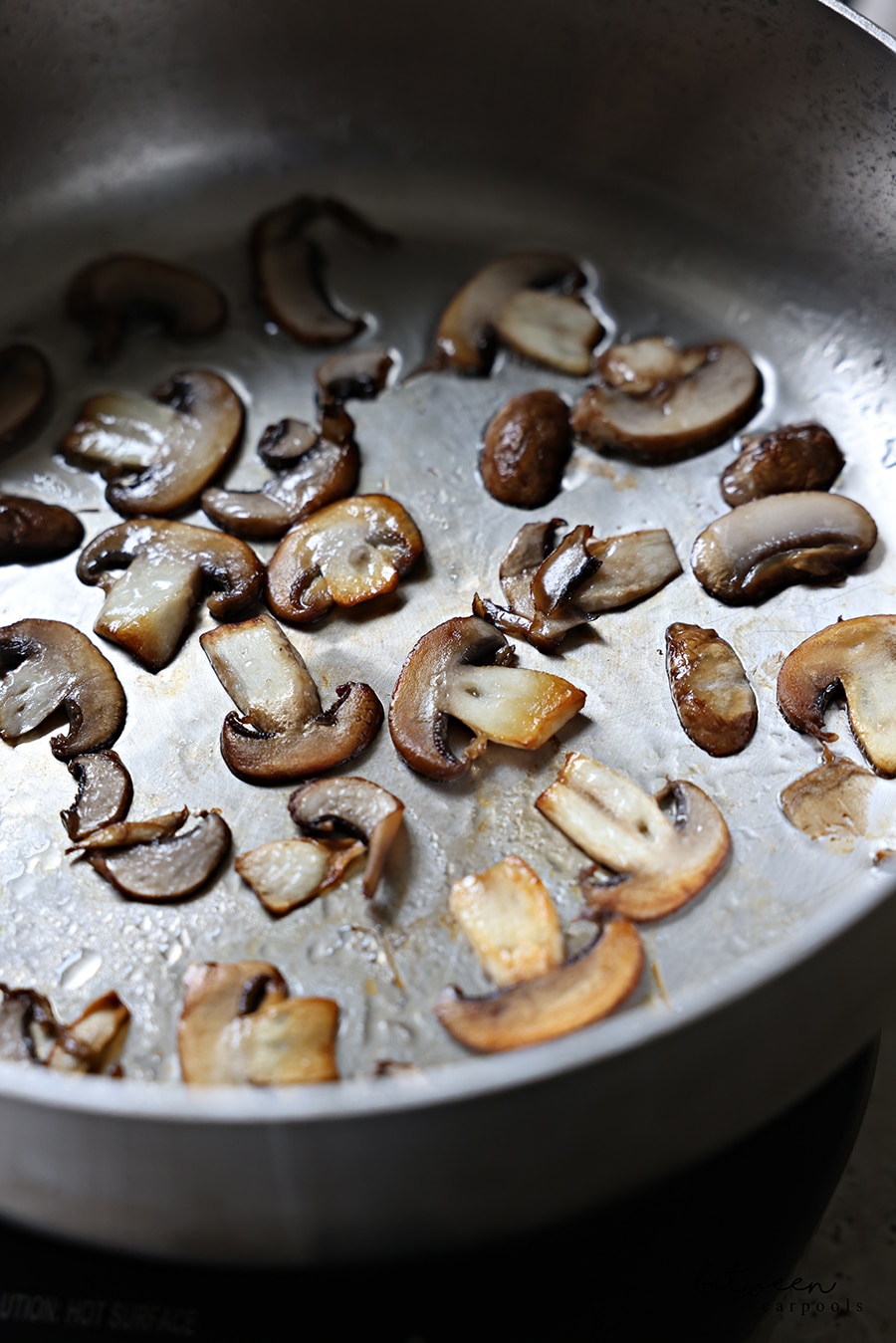 Mushrooms sautéing in a pan.
