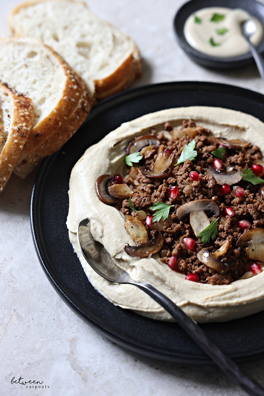 Ground beef in the center of plated chummus.