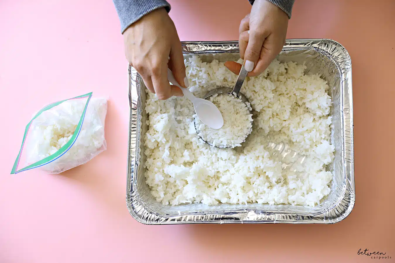 Measuring cooked rice from a 9 x 13 foil pan and filling a ziploc bag