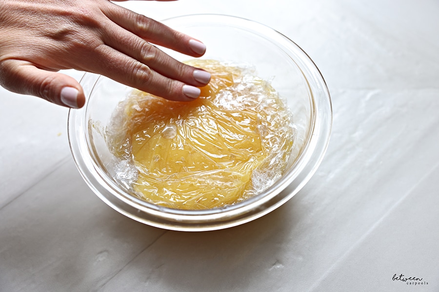Curd in a bowl covered with plastic wrap.
