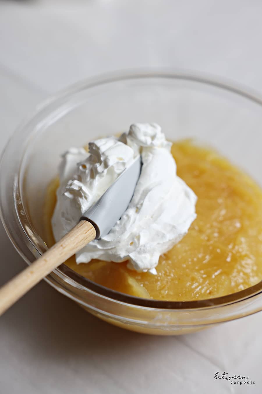Folding some whipped topping into the cooled curd.