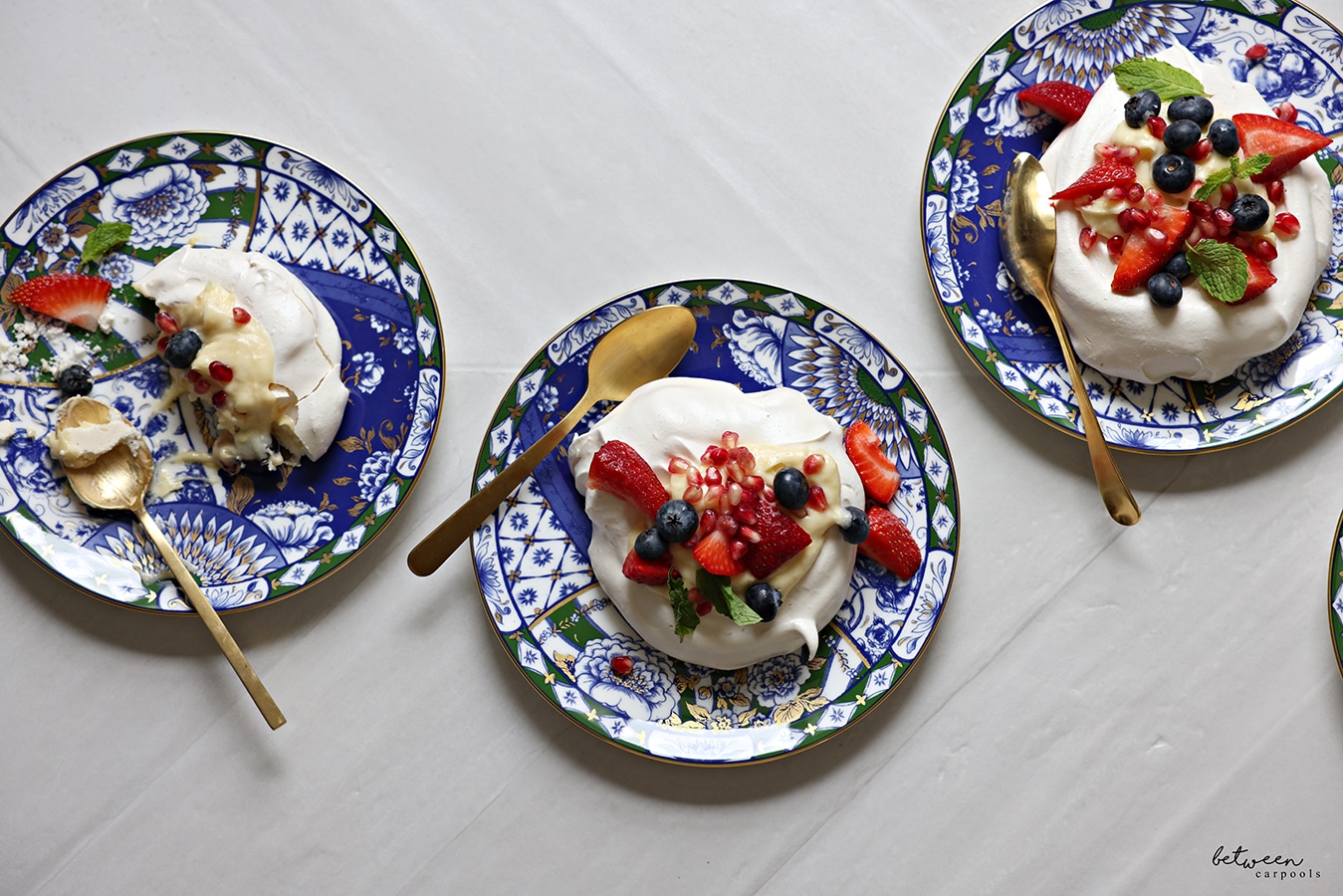 Assembled pavlovas on 3 dessert plates.