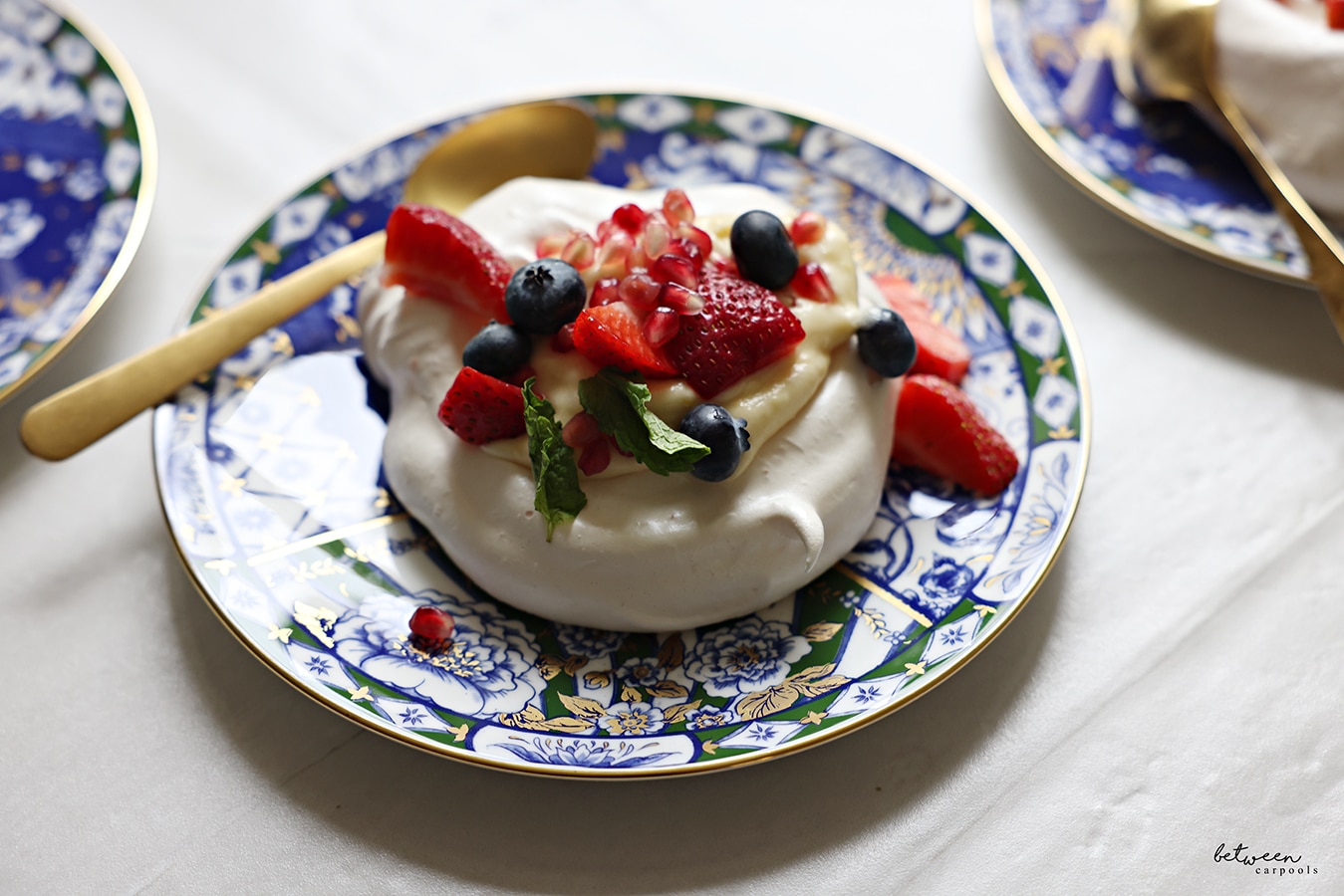 Assembled pavlova with berries and mint leaves.