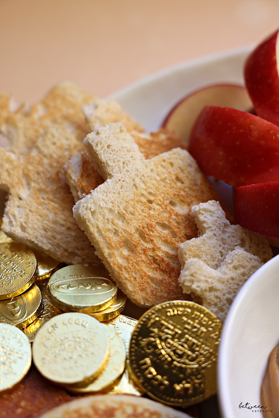 Toast in dreidel shape, Chanukah gelt, sliced apples - part of a Chanukah breakfast board
