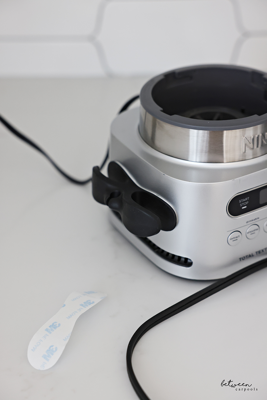 Ninja smoothie machine with an appliance cord wrap on the kitchen counter.