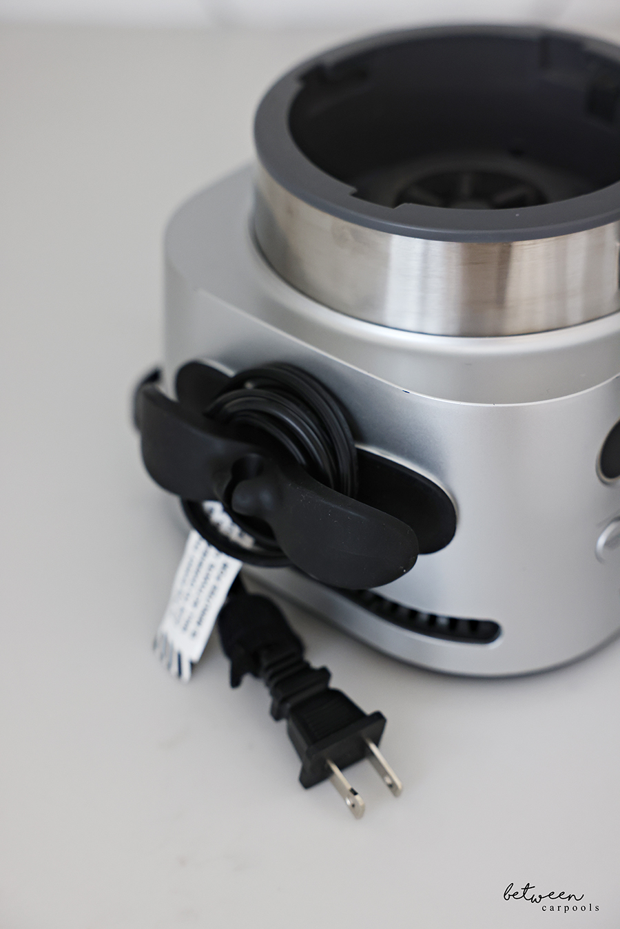Ninja smoothie machine with its wire wrapped around an appliance cord wrap on the kitchen counter