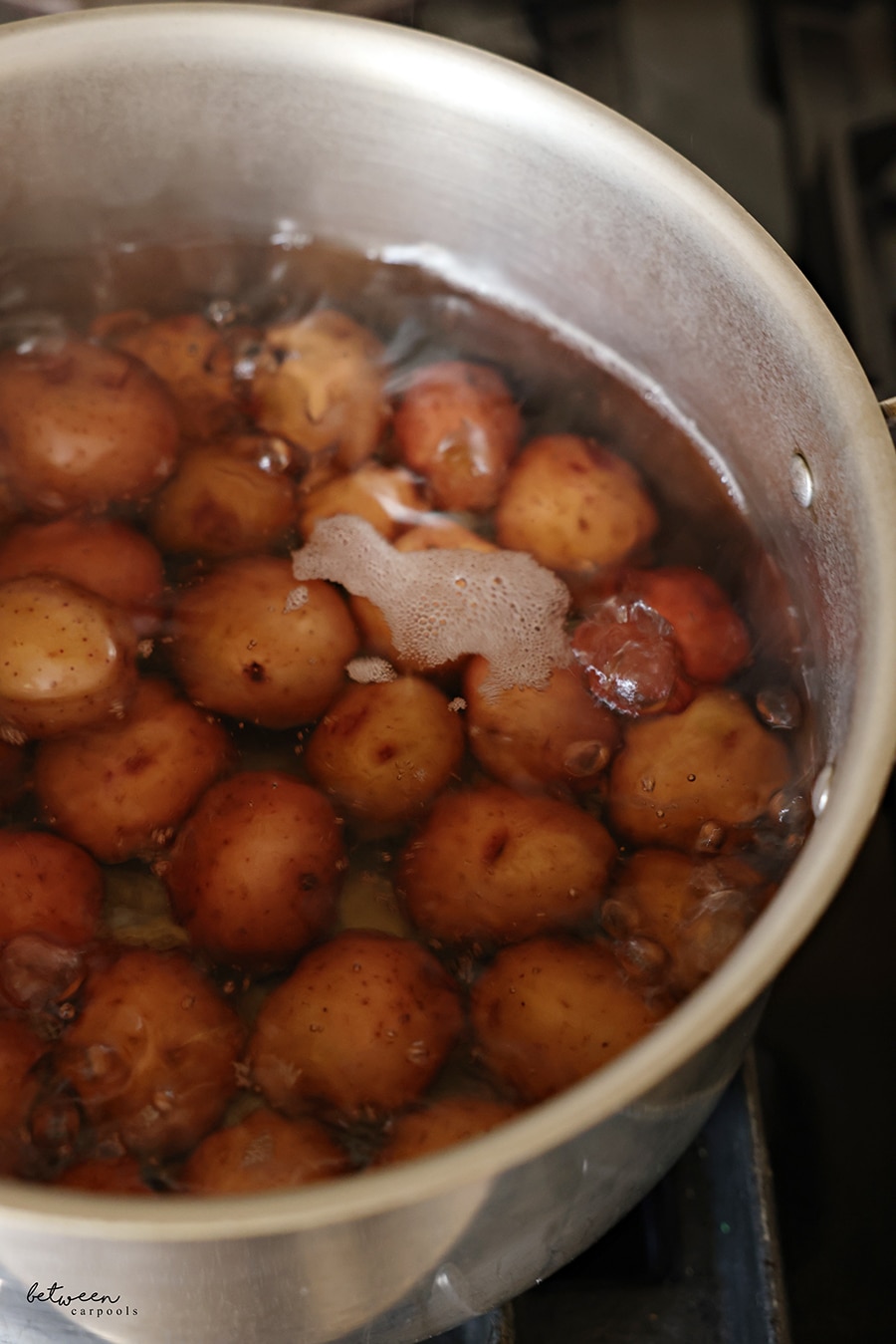 Baby red potatoes in a pot of boiling water.