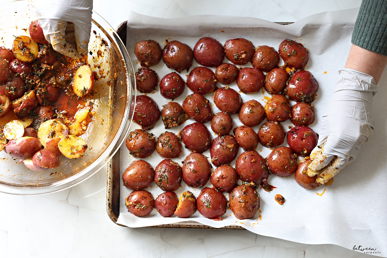 Placing coated halved red potatoes, cut side down, on a parchment lined baking sheet.