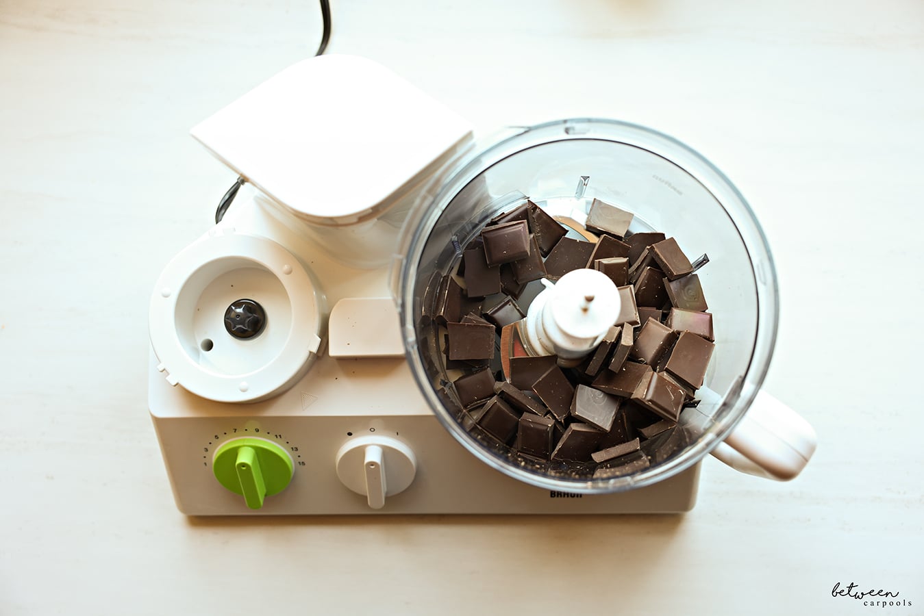 Chocolate in the bowl of a food processor fitted with the “S” blade.