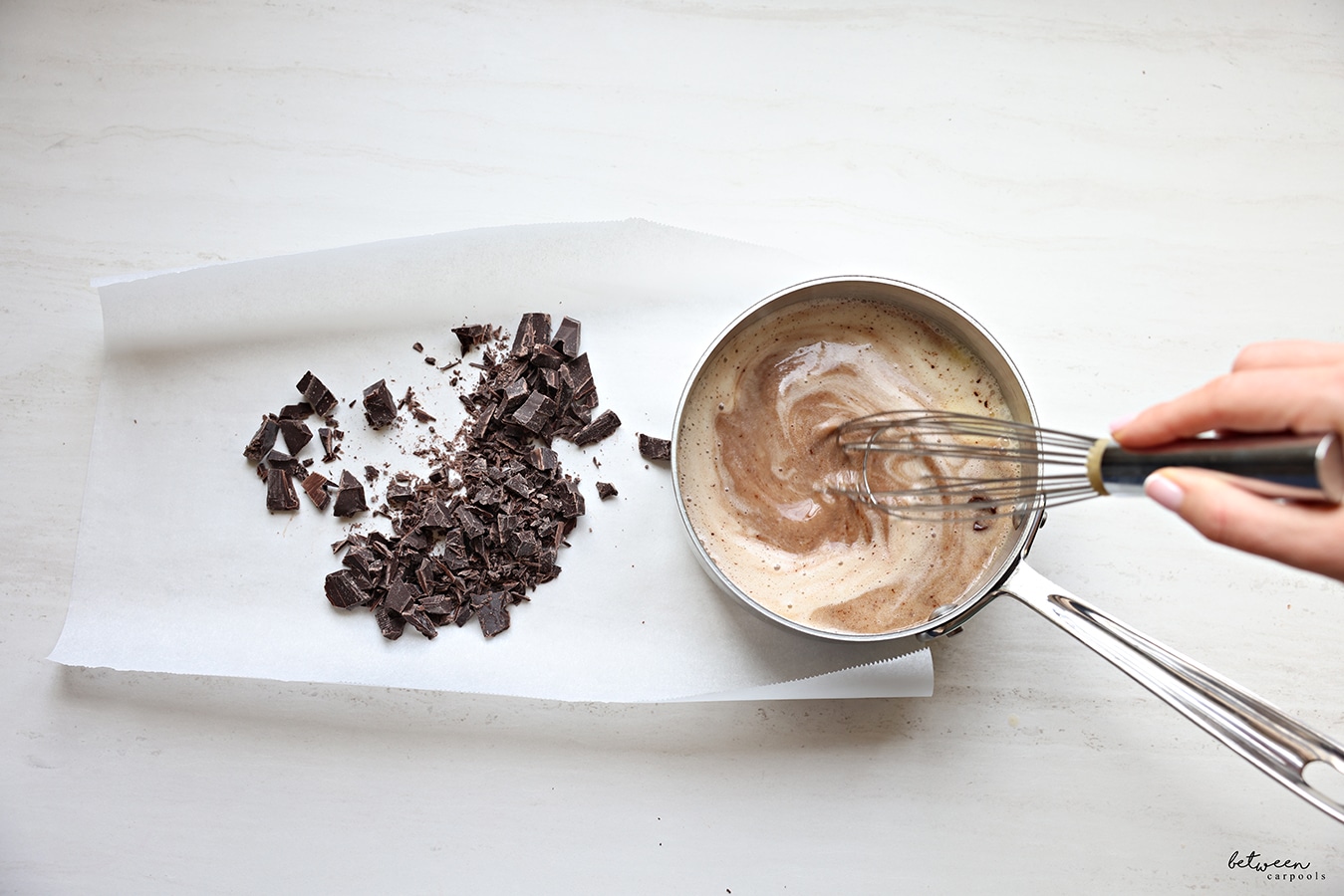 Whisking chopped chocolate into the cream mixture.