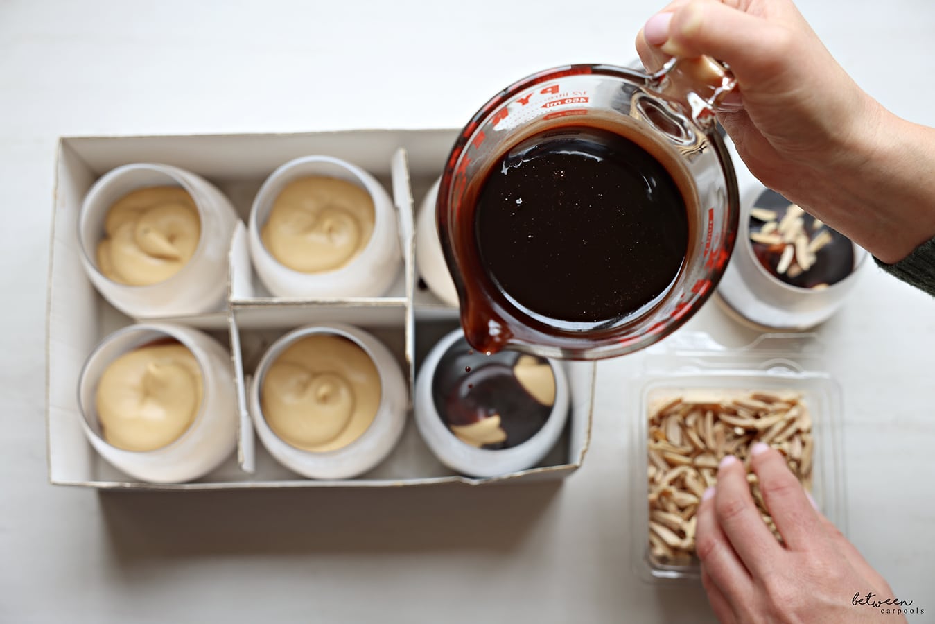Topping each glass of mousse with a bit of glaze.