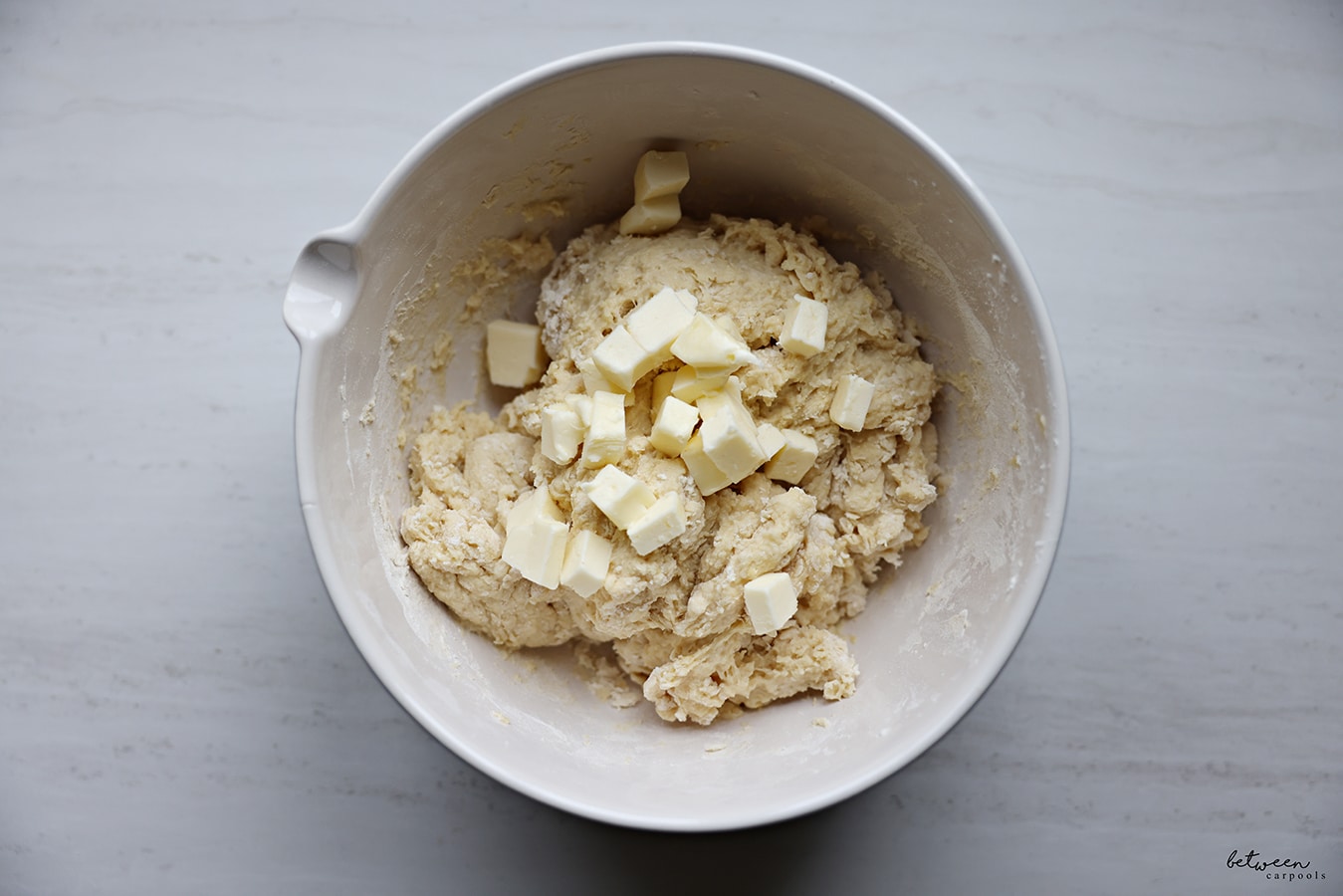 Small pieces of butter added to the bowl of dough.