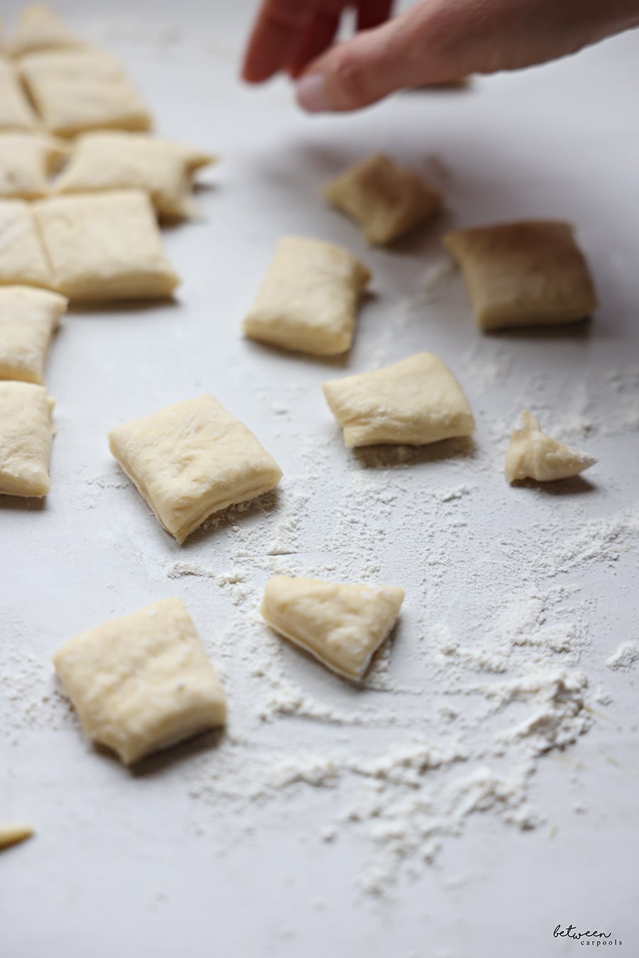 Squares of rolled dough on a floured counter.