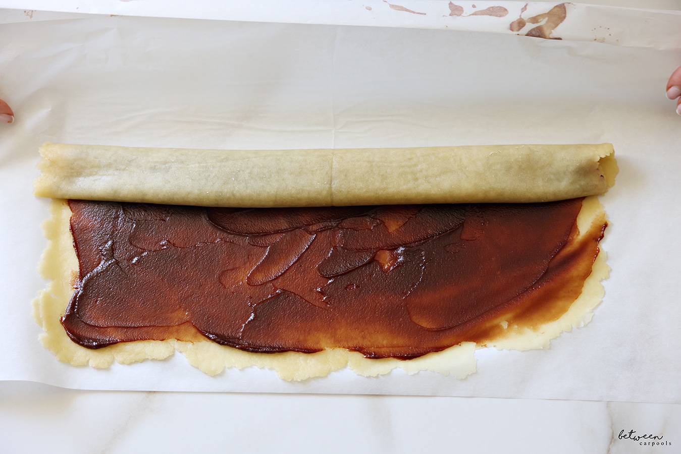 Continuing to roll the dough rolled flat into a large rectangle jelly-roll style.