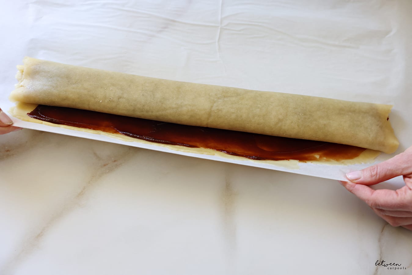 Getting to the end of rolling the dough rolled flat into a large rectangle jelly-roll style.