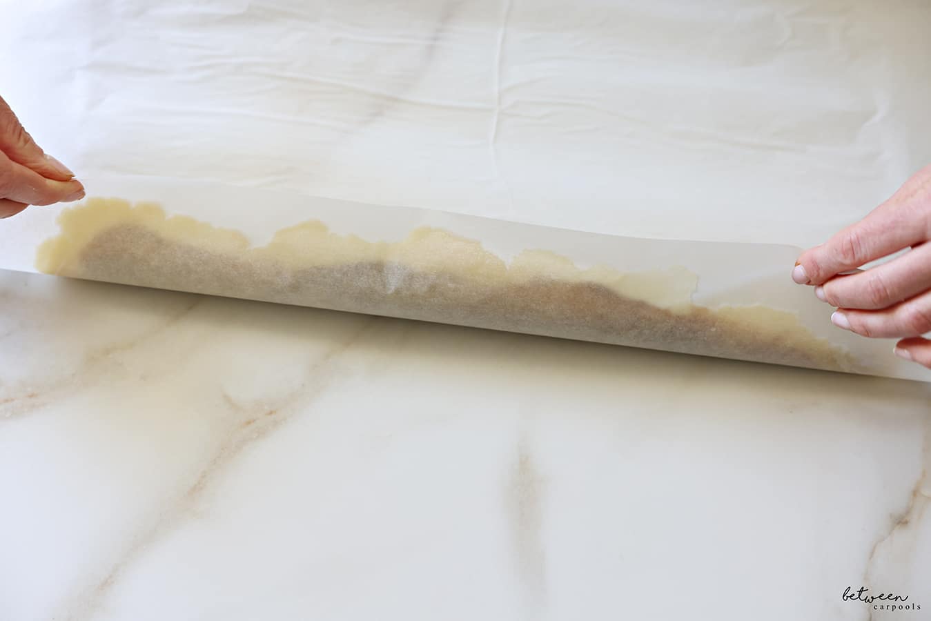 Sealing the edge of the dough rolled jelly-roll style.