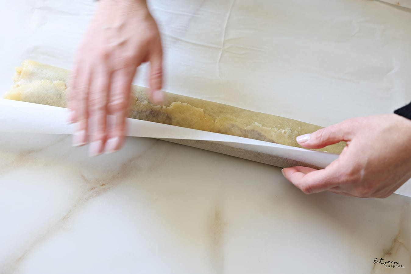 Sealing the edges of the dough rolled jelly-roll style.