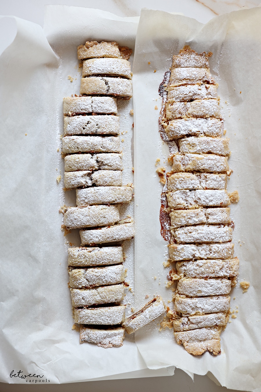 2 rolls of baked date spread cookies with confectioners' sugar.