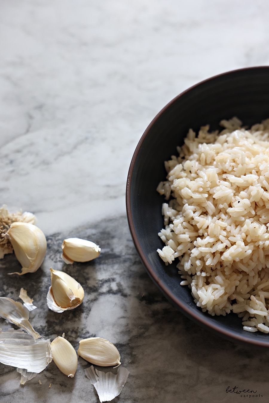 Garlic Toasted Rice, plated, with cloves of garlic nearby.