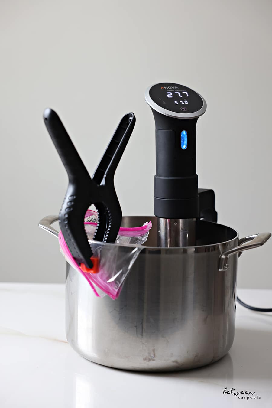 2 Ziploc bags with oyster steaks and marinades in and clipped to a pot with a sous vide.