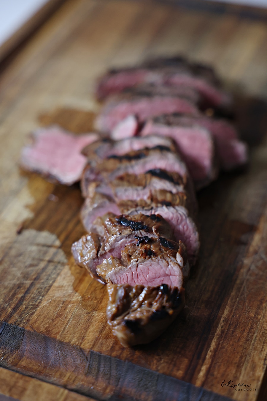 A sliced oyster steak, sous vide and grilled, on a wooden cutting board.