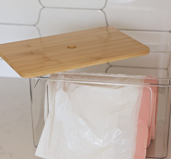 Garbage bag dispenser bin with a roll of garbage bags.