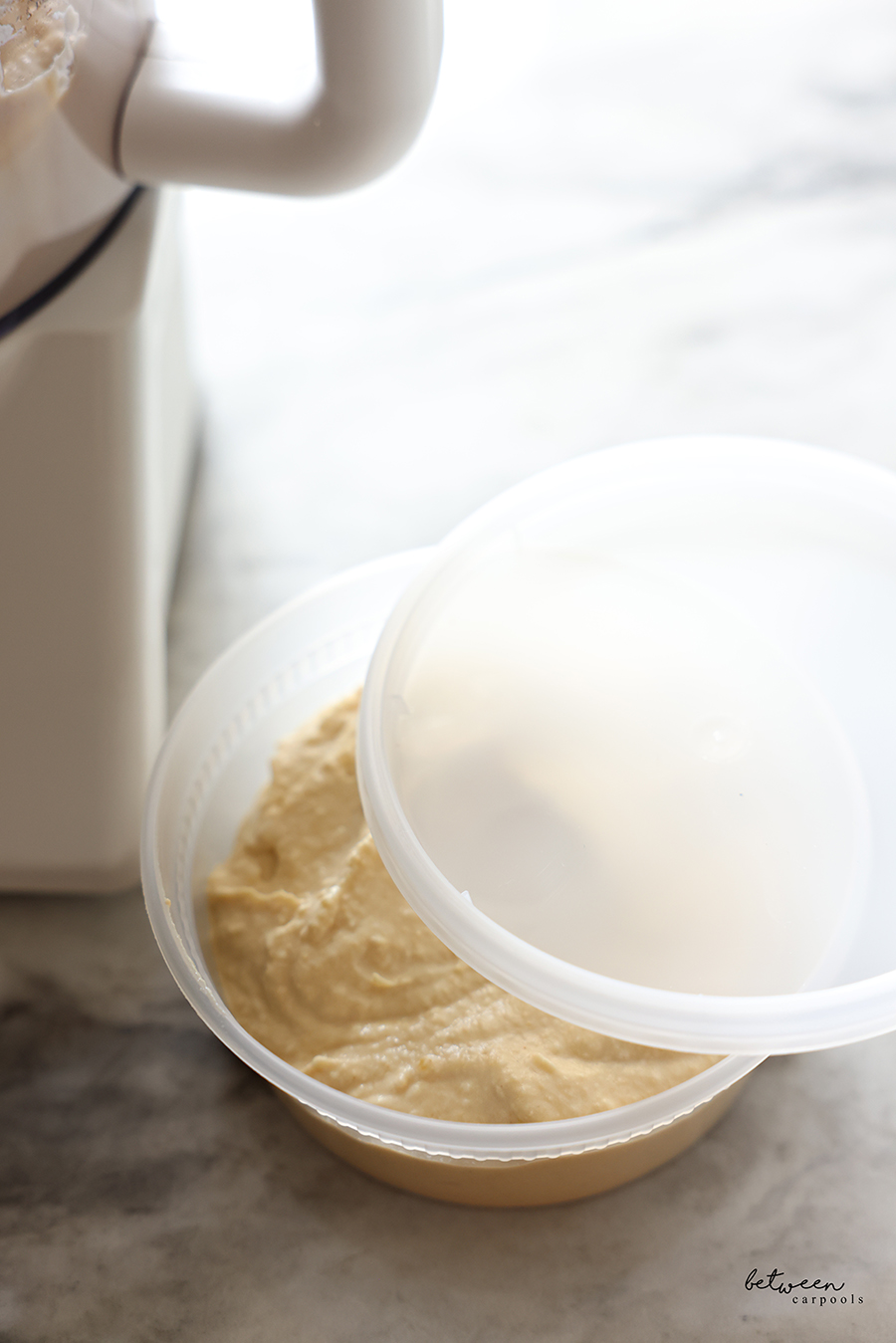 Homemade chummus in an 8 oz. plastic deli container.